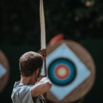 man shooting at archery target